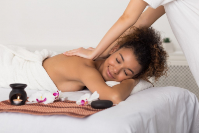 woman having back aroma massage in spa salon, relaxing with closed eyes