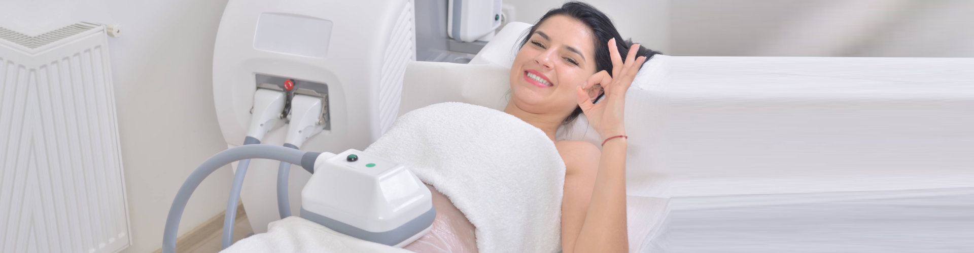 pretty young woman getting cryolipolyse treatment in professional cosmetic cabinet